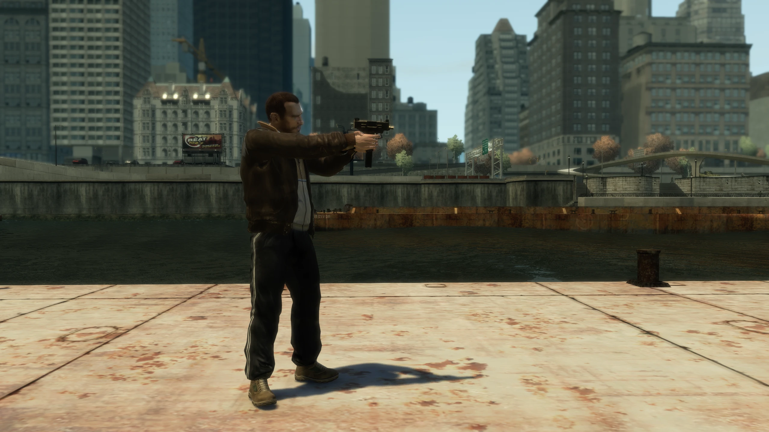 A screenshot of Niko holding the Uzi SMG in GTA IV. On console he holds it further to his body with his arms fully stretched out in front of him.